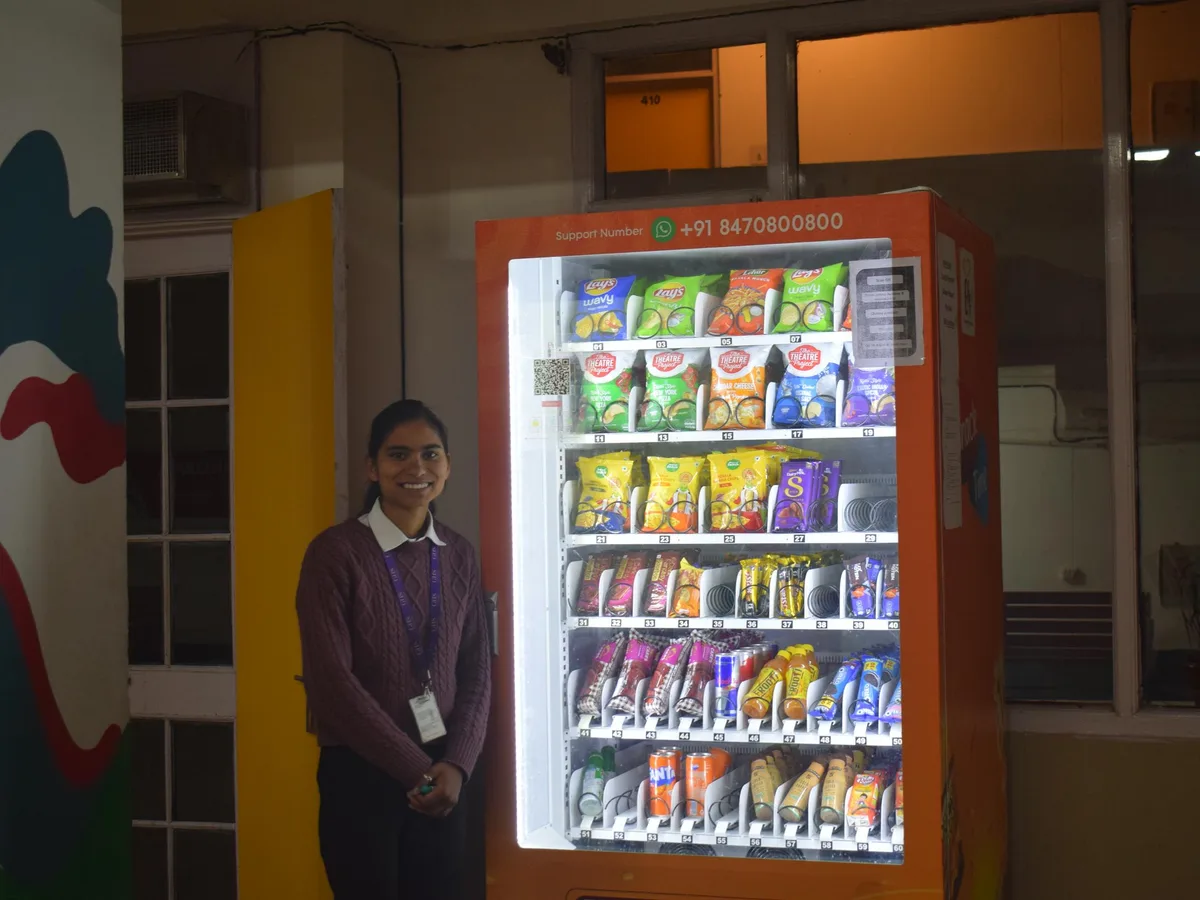A sleek touchscreen cashless reader mounted on the front of a modern vending machine