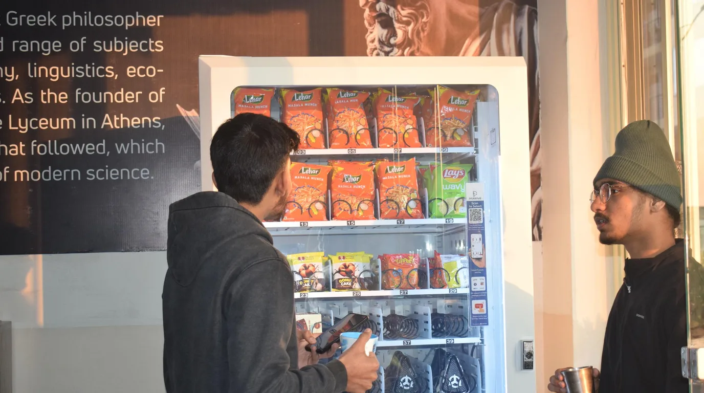 Vending machine in a busy corridor with a lingering captive audience nearby