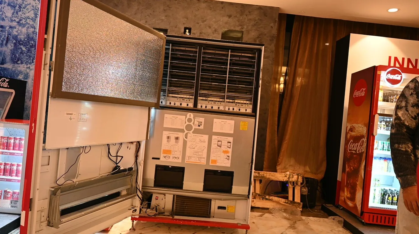 Cutaway of a refrigerated vending machine showing compressor, lighting, and electronics