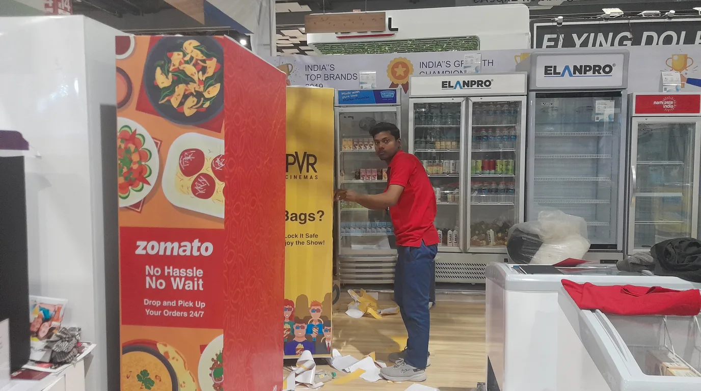 Operator analyzing sales data beside a stocked vending machine to control costs